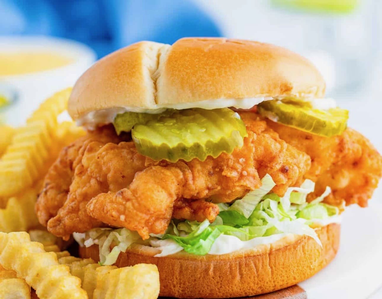Crispy fried chicken sandwich with pickles and lettuce.