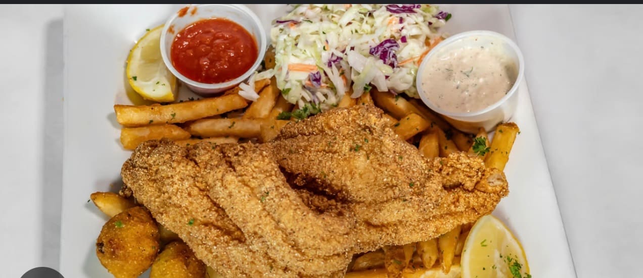 Fried catfish served with fries, coleslaw, and dipping sauce.