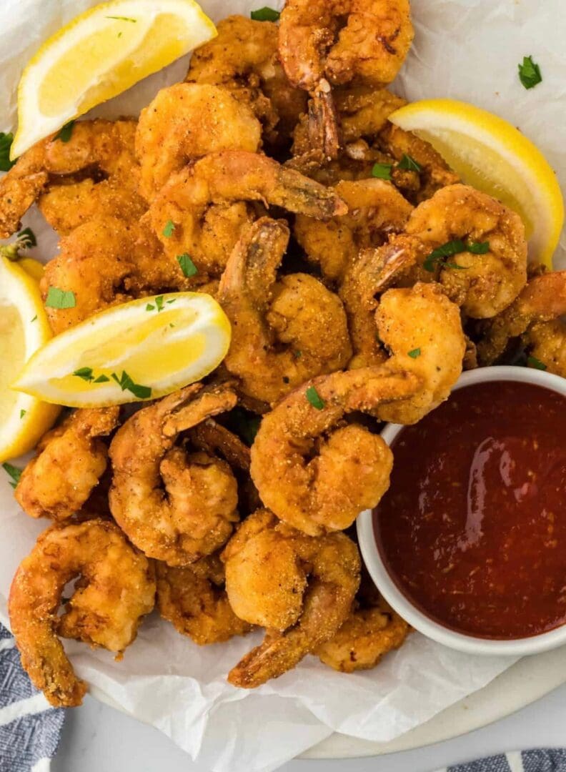 Crispy fried shrimp served with lemon wedges and cocktail sauce.